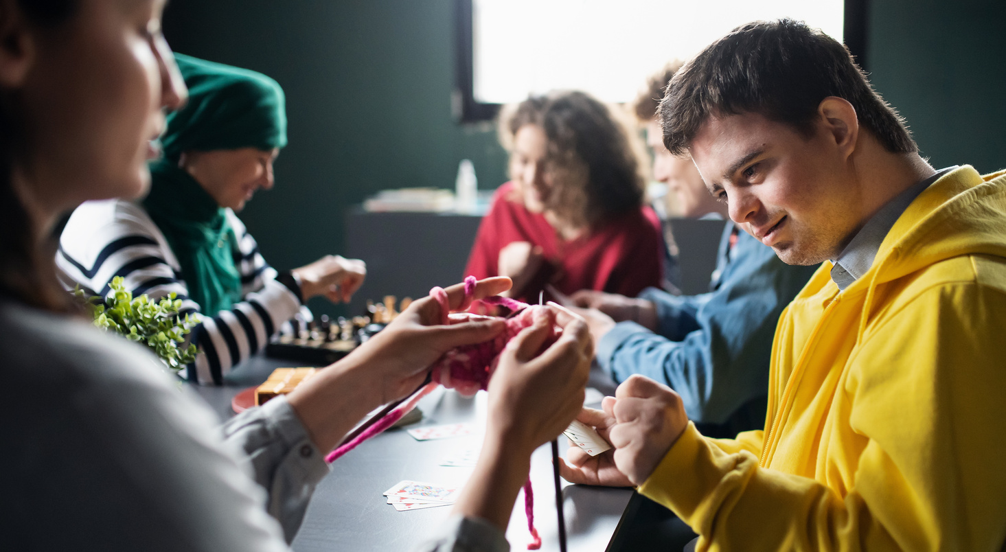 Group of People Playing Cards and Board Games in Community Center, Inclusivity of Disabled Person.